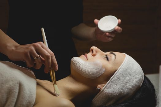 Close-up of young woman with facial mask in spa