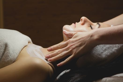 Close-up of young woman with facial mask in spa