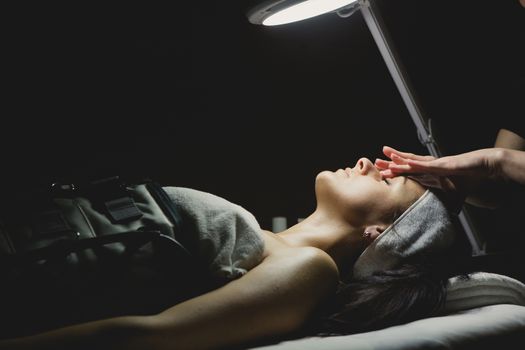 Close-up of young woman with facial mask in spa