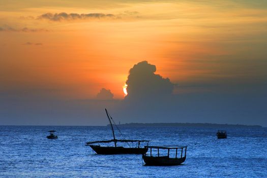Traditional fishing boats in ocean on sunset. Zanzibar