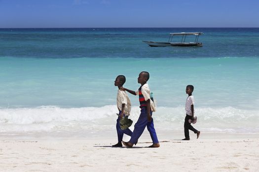 Zanzibar, Tanzania - January 6, 2016: Three unknown African boy walking on the beach in Zanzibar