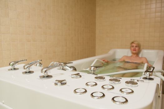 A woman and a hydro massage. She receives medical treatments for relaxation.