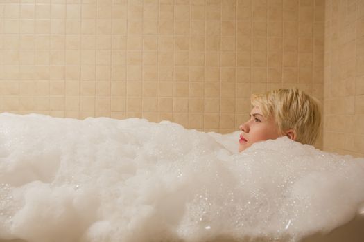 A woman and a hydro massage. She receives medical treatments for relaxation.