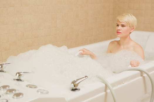 A woman and a hydro massage. She receives medical treatments for relaxation.