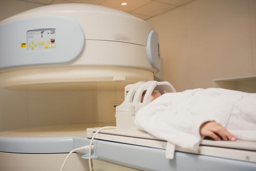 Patient being scanned and diagnosed on a computed tomography scanner in a hospital. Modern medical equipment, medicine and health care concept.