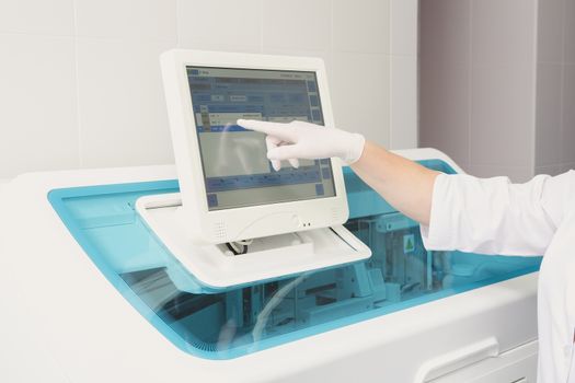 Lab tech loading samples into a chemistry analyzer in clinic