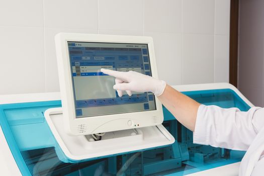 Lab tech loading samples into a chemistry analyzer in clinic