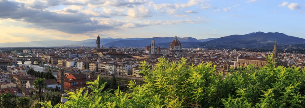 Top view of Florence city with arno river bridges and historical buildings, on cloudy sunrise or sunset sky background.