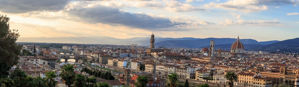 Top view of Florence city with arno river bridges and historical buildings, on cloudy sunrise or sunset sky background.