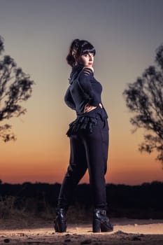 View of a beautiful young girl in gothic clothing on the nature.