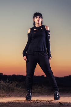 View of a beautiful young girl in gothic clothing on the nature.