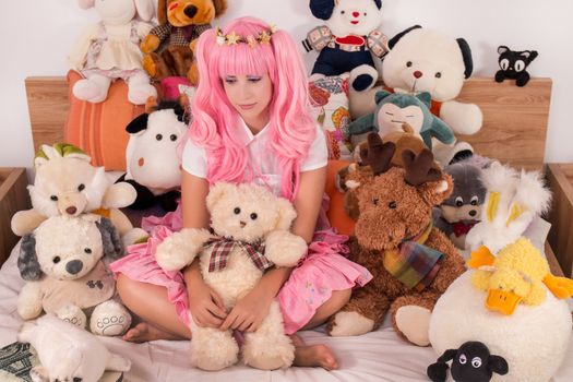 young girl in a bedroom in a pink cute dress