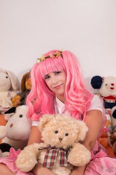 young girl in a bedroom in a pink cute dress