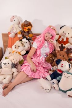 young girl in a bedroom in a pink cute dress