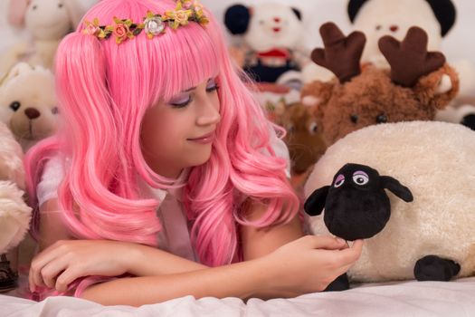 young girl in a bedroom in a pink cute dress