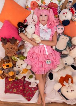 young girl in a bedroom in a pink cute dress