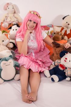 young girl in a bedroom in a pink cute dress