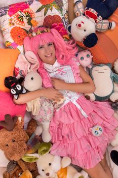 young girl in a bedroom in a pink cute dress