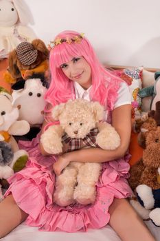 young girl in a bedroom in a pink cute dress