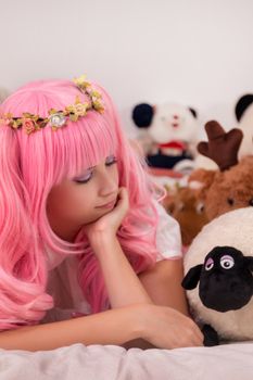 young girl in a bedroom in a pink cute dress