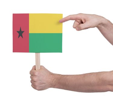 Hand holding small card, isolated on white - Flag of Guinea Bissau