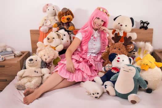 young girl in a bedroom in a pink cute dress