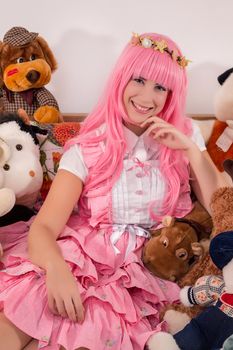 young girl in a bedroom in a pink cute dress