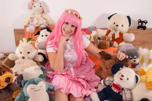 young girl in a bedroom in a pink cute dress