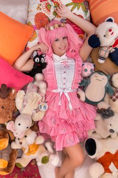 young girl in a bedroom in a pink cute dress