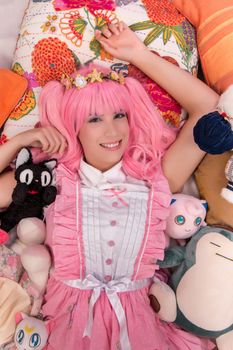 young girl in a bedroom in a pink cute dress