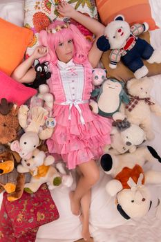 young girl in a bedroom in a pink cute dress