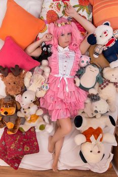 young girl in a bedroom in a pink cute dress