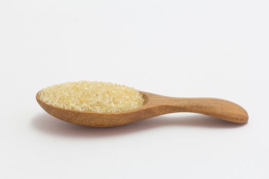 brown sugar in wooden spoon isolated on white