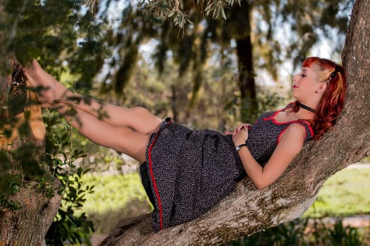 View of a young woman with a simple spring dress posing on the park.