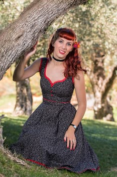 View of a young woman with a simple spring dress posing on the park.