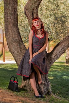 View of a young woman with a simple spring dress posing on the park.