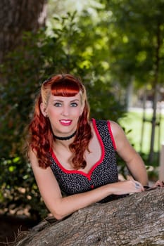 View of a young woman with a simple spring dress posing on the park.