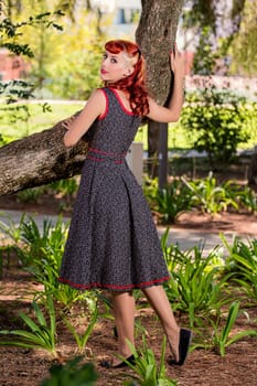 View of a young woman with a simple spring dress posing on the park.