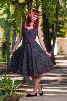 View of a young woman with a simple spring dress posing on the park.