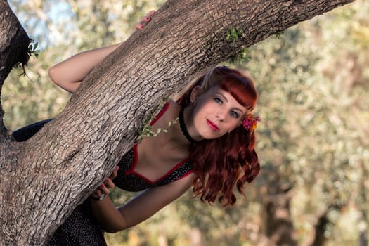 View of a young woman with a simple spring dress posing on the park.