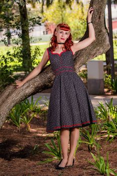 View of a young woman with a simple spring dress posing on the park.