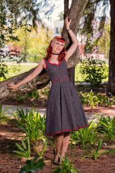 View of a young woman with a simple spring dress posing on the park.