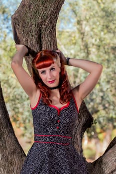 View of a young woman with a simple spring dress posing on the park.