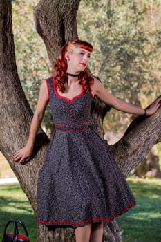 View of a young woman with a simple spring dress posing on the park.