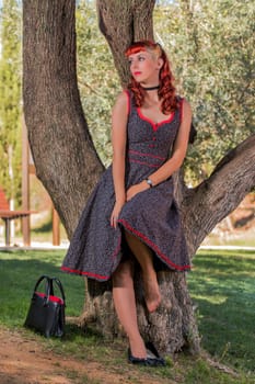 View of a young woman with a simple spring dress posing on the park.