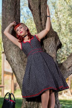 View of a young woman with a simple spring dress posing on the park.