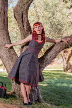 View of a young woman with a simple spring dress posing on the park.