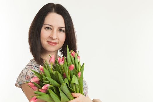 the beautiful woman holds a bouquet of tulips