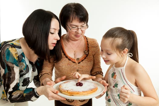 the grandmother holds the pie made for the daughter and the granddaughter