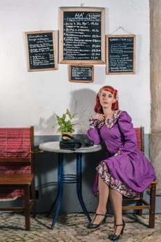 Close up view of a young redhead girl on a retro vintage dress on the urban city.